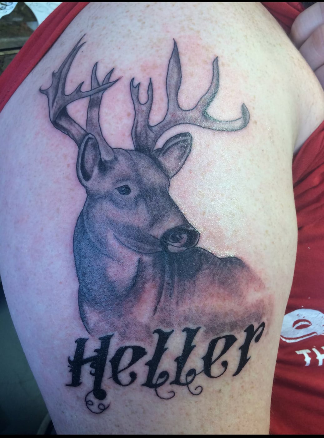 Realistic black and grey whitetail buck with a full rack of antlers on a shoulder, a family name lettered beneath it